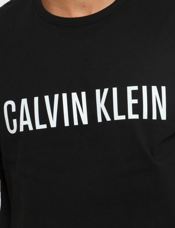 T-shirt Calvin Klein Nero - T-shirt su sfondo nero con stampa logo brand bianco. La vestibilità è morbida e regolare. La t-s