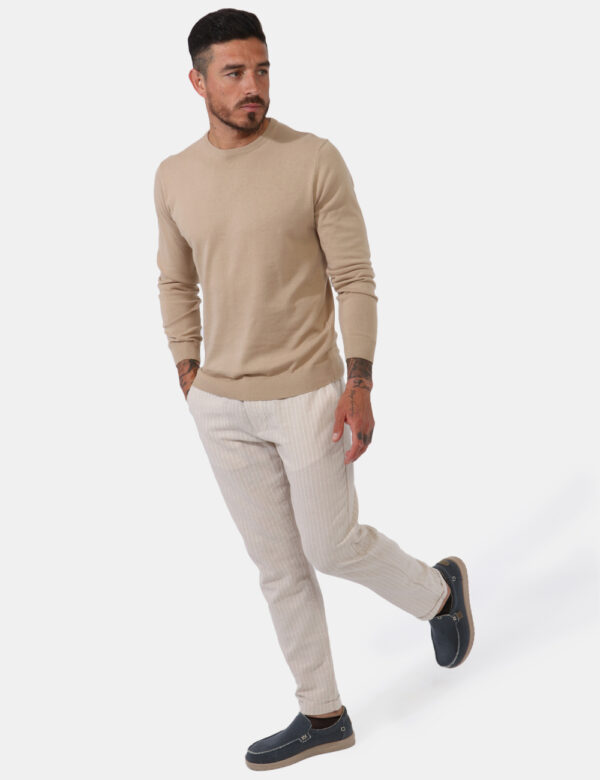 Pantaloni Goha Beige - Pantaloni leggeri su base beige ma rigato bianco. Presenti tasche a taglio trasversale sul fronte e