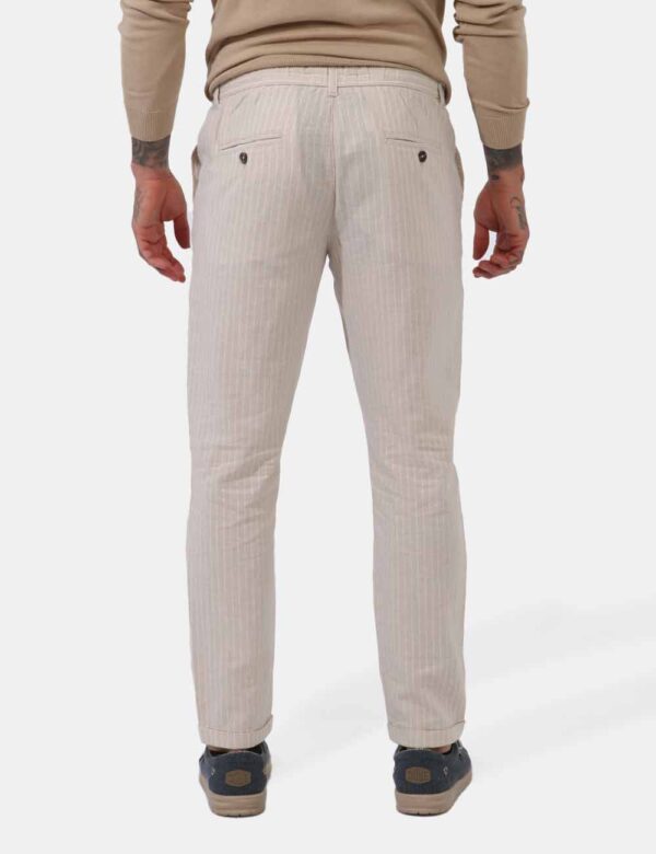 Pantaloni Goha Beige - Pantaloni leggeri su base beige ma rigato bianco. Presenti tasche a taglio trasversale sul fronte e