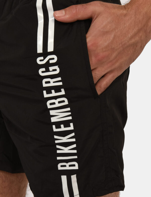 Costume Bikkembergs Nero - Costume modello shorts in 100% poliestere. Il capo si sviluppa in total nero con logo brand bianc