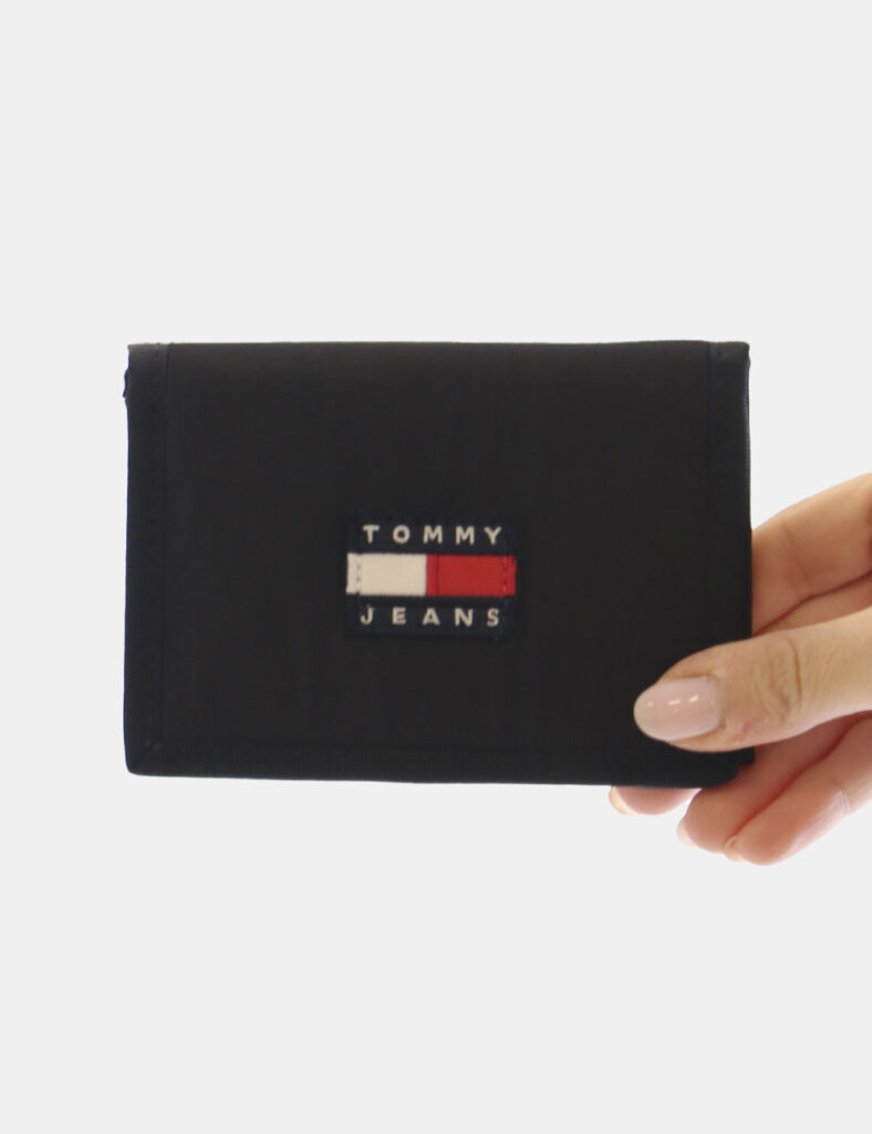 Portafogli Tommy Hilfiger Nero - Portafoglio in nylon nero con strap e logo frontale. Al suo interno presenta quattro taschi