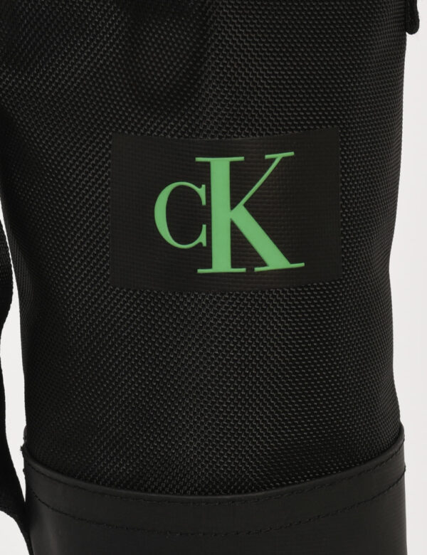 Borsello Calvin Klein Nero - Borsello da uomo a forma circolare in total nero con patch logo brand verde. Presente un unico