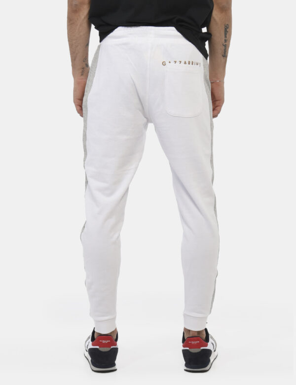 Pantaloni Gazzarrini Bianco - Pantaloni da tuta in total bianco con bande laterali grigie. Presenti tasche a taglio trasvers