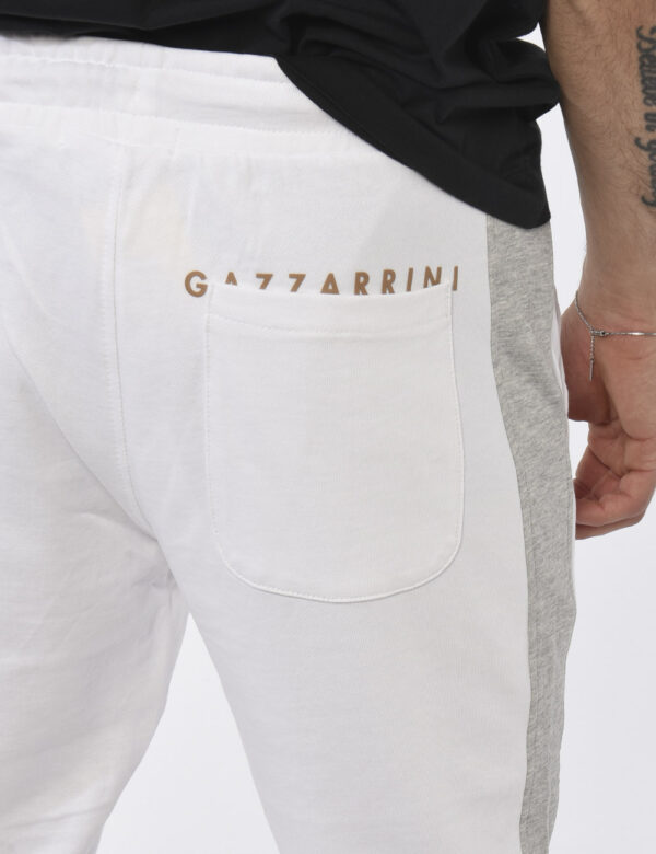 Pantaloni Gazzarrini Bianco - Pantaloni da tuta in total bianco con bande laterali grigie. Presenti tasche a taglio trasvers