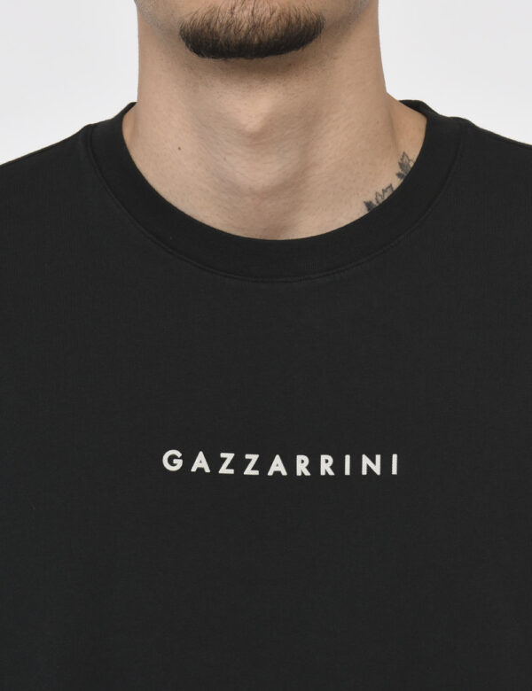 T-shirt Gazzarrini Nero - T-shirt classica su base nero slavato con logo brand bianco. La vestibilità è morbida e regolare.