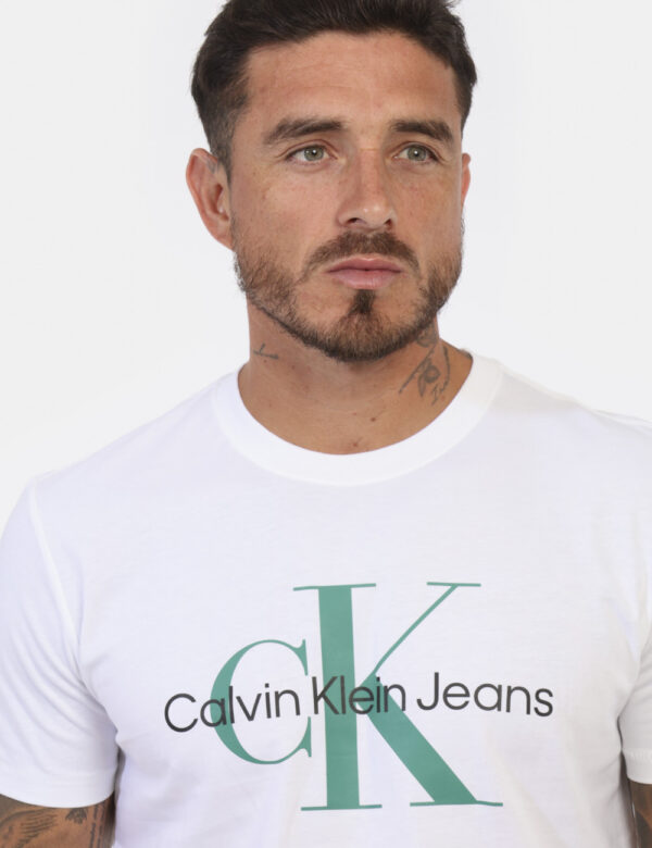 T-shirt CALVIN KLEIN Bianco - T-shirt classica in total bianco con stampa logo brand nero e verde sul fronte. La vestibilità