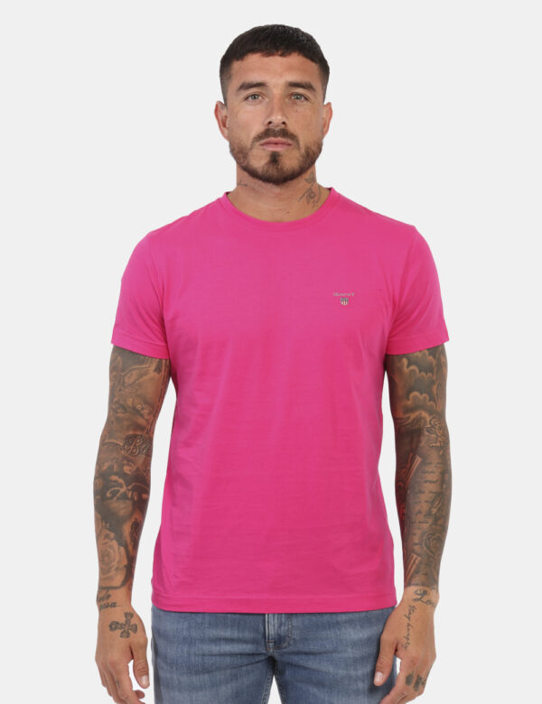 T-Shirt Gant Rosa - T-shirt classica in total rosa fluo con patch logo brand ad altezza cuore. La vestibilità è morbida e re