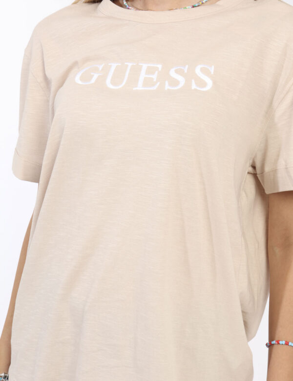 T-shirt Guess Beige - T-shirt classica in total beige con stampa logo brand ricamato bianco. La vestibilità è morbida e rego