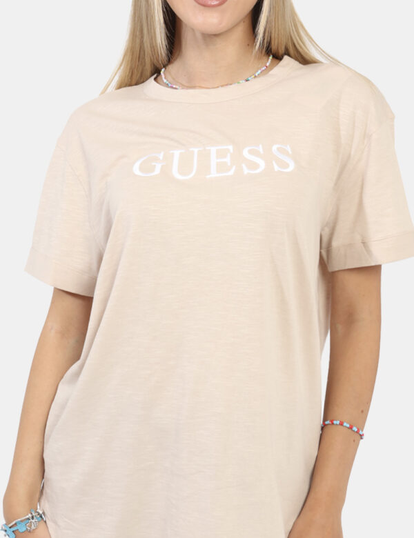 T-shirt Guess Beige - T-shirt classica in total beige con stampa logo brand ricamato bianco. La vestibilità è morbida e rego