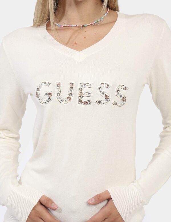 Maglione Guess Bianco - Maglione in total bianco panna con scollo a V e stampa logo brand con glitter. La vestibilità è morb