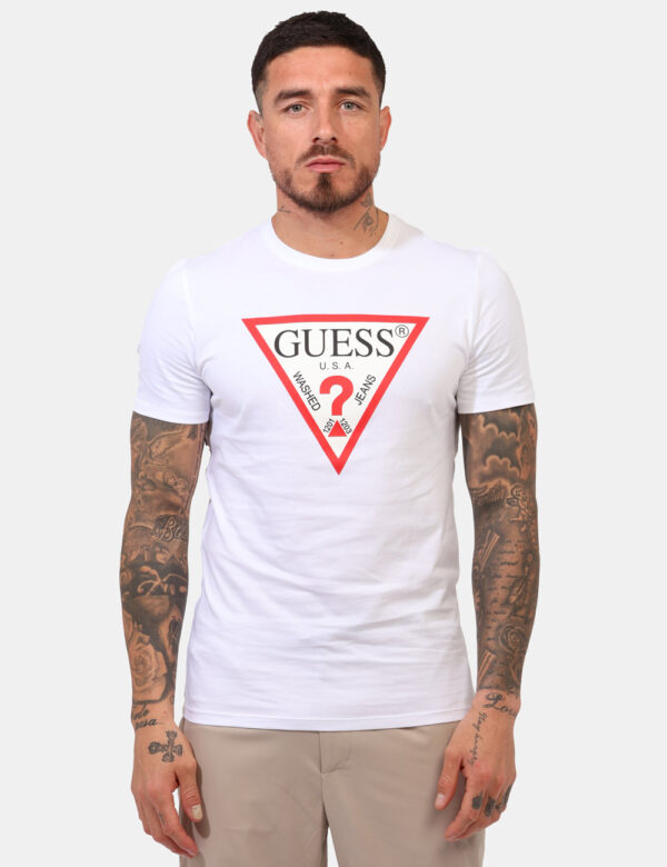 T-shirt Guess Bianco - T-shirt classica in total bianco con stampa logo brand in bianco e rosso. La vestibilità è morbida e