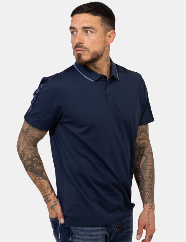 Polo Guess Blu - Polo in total blu navy con patch logo brand in tinta sulla manica. La vestiibilità è morbida e pratica graz