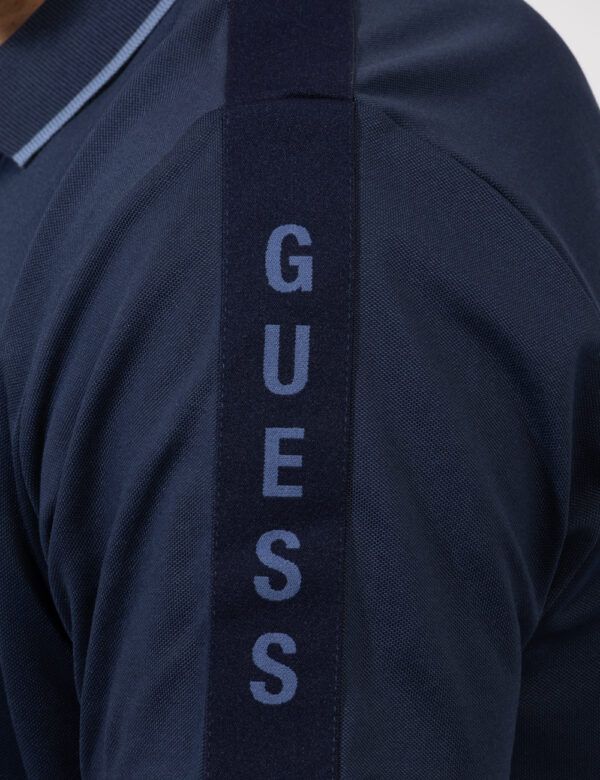 Polo Guess Blu - Polo in total blu navy con patch logo brand in tinta sulla manica. La vestiibilità è morbida e pratica graz