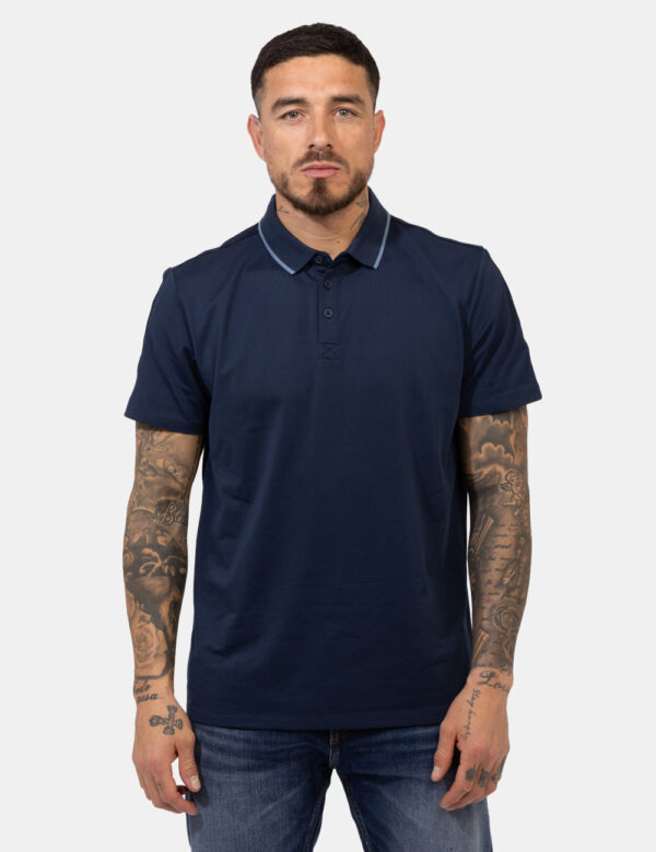 Polo Guess Blu - Polo in total blu navy con patch logo brand in tinta sulla manica. La vestiibilità è morbida e pratica graz