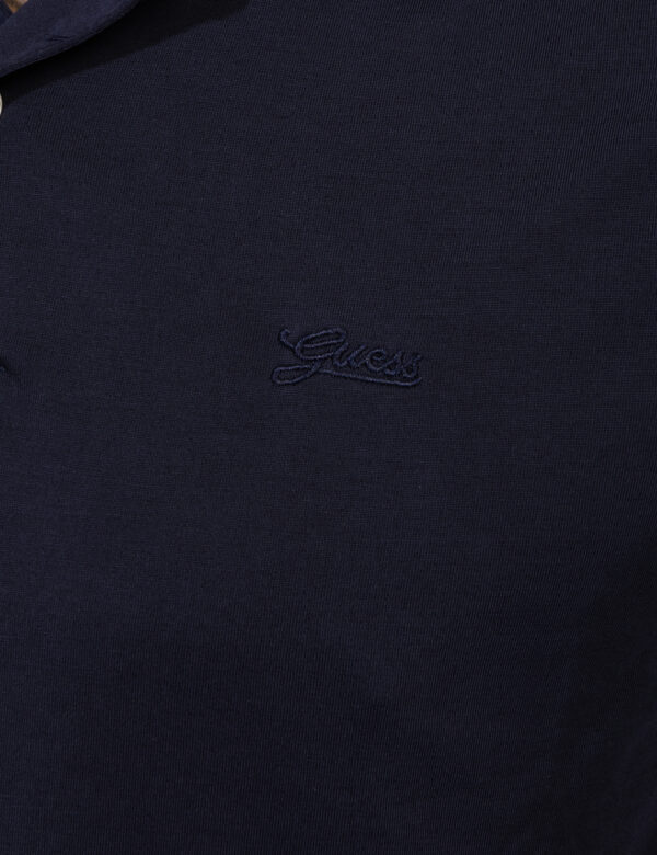 T-shirt Guess Blu - T-shirt simil polo, in total blu navy con logo brand ricamato ad altezza cuore. La vestibilità è morbida