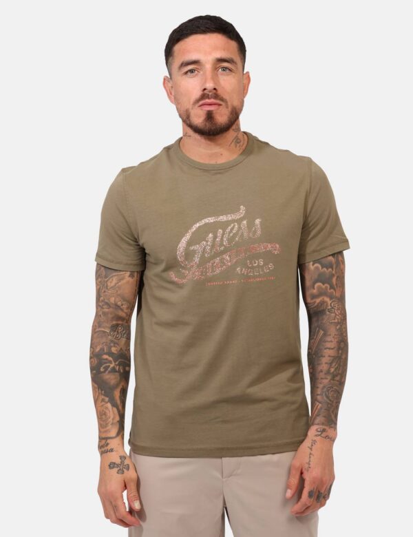 T-shirt Guess Verde - T-shirt classica su base verde militare con stampa logo brand in tinta coordinata. La vestibilità è mo