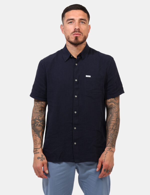 Camicia Guess Blu - Camicia a maniche corte, in misto lino/cotone, ed in total blu navy. Presente taschino a toppa. La vesti