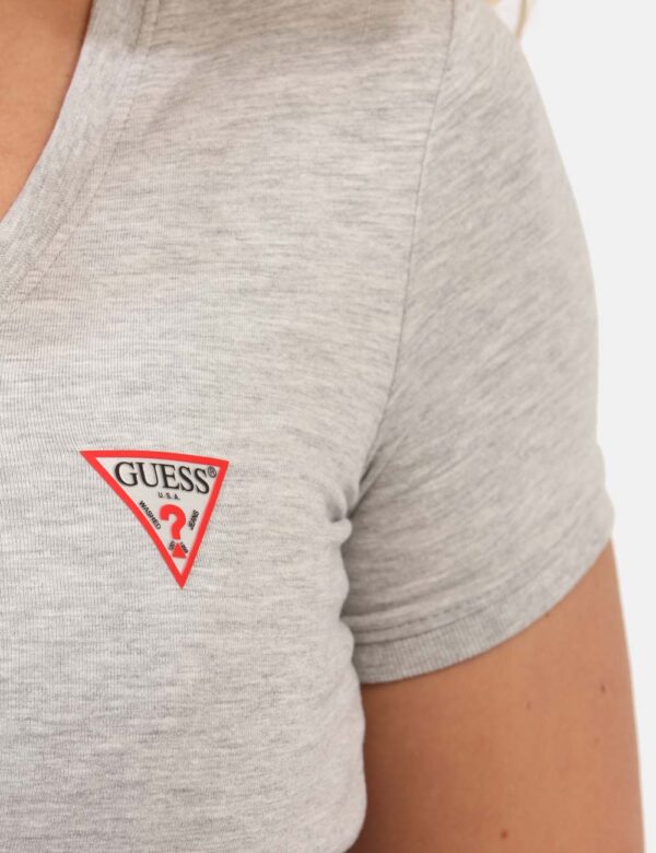 T-shirt Guess Grigio - T-shirt con scollo a V in total grigio chiaro con patch logo brand ad altezza cuore. La vestibilità è