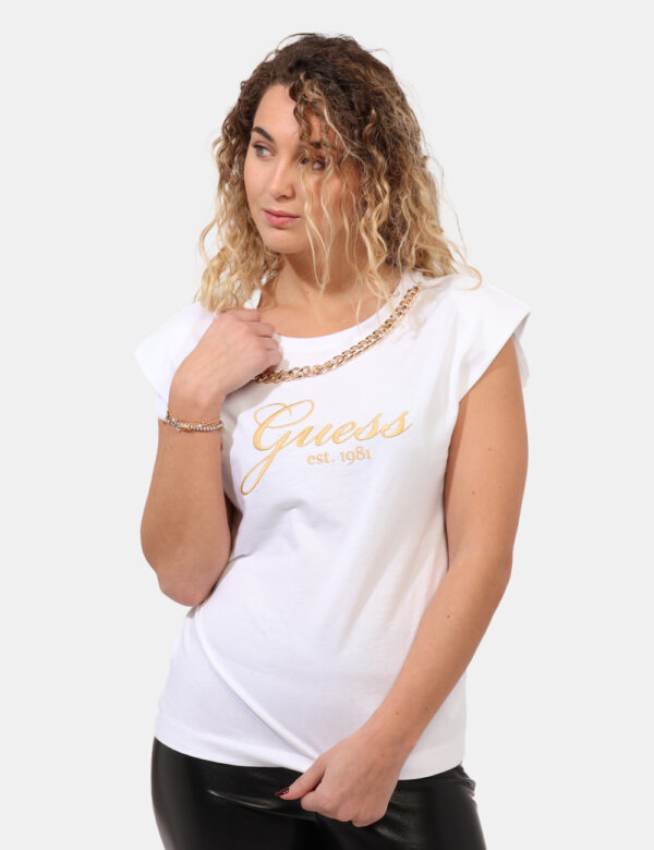 T-shirt Guess Bianco - T-shirt su base bianca con stampa ricamata logo brand in tinta dorata. Presente ulteriore dettaglio c