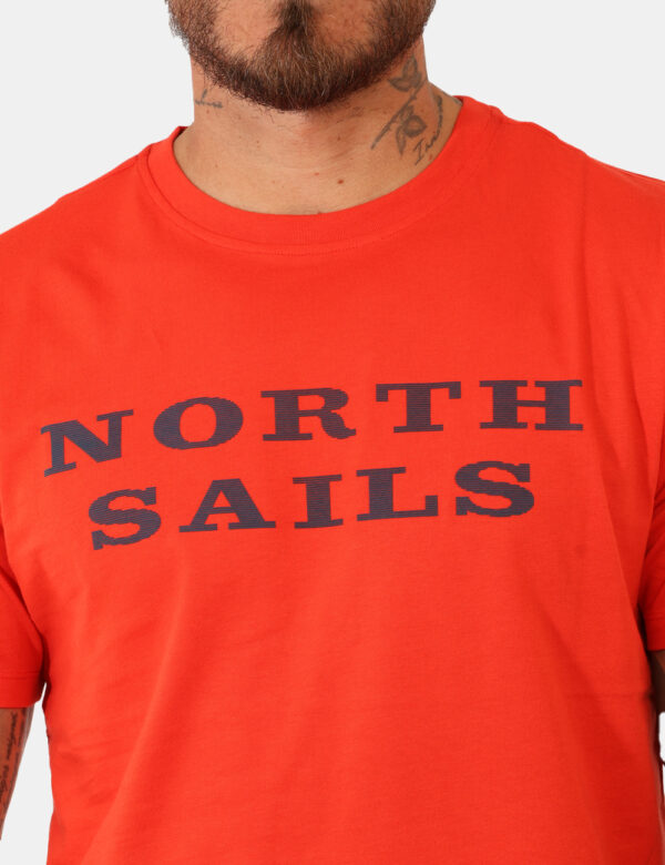 T-shirt North Sails Arancione - T-shirt classica su base arancione con stampa brand in blu. La vestibilità è morbida e regol
