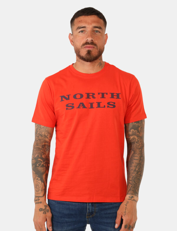 T-shirt North Sails Arancione - T-shirt classica su base arancione con stampa brand in blu. La vestibilità è morbida e regol