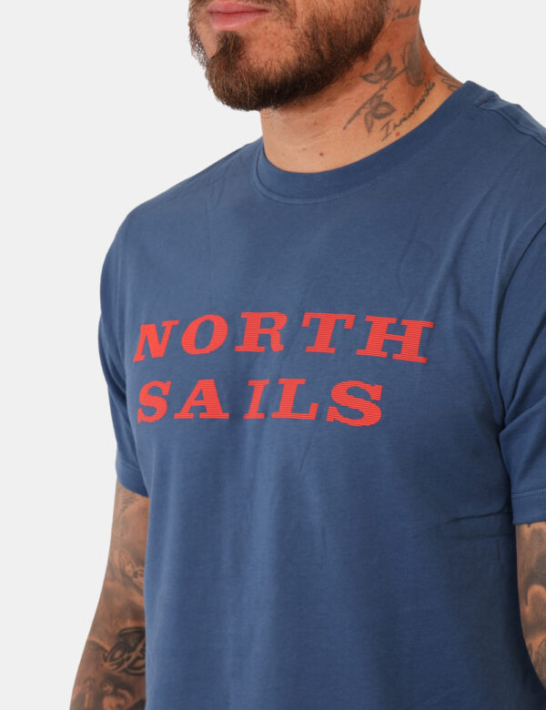 T-shirt North Sails Blu - T-shirt classica su base blu con stampa brand in arancione. La vestibilità è morbida e regolare. L