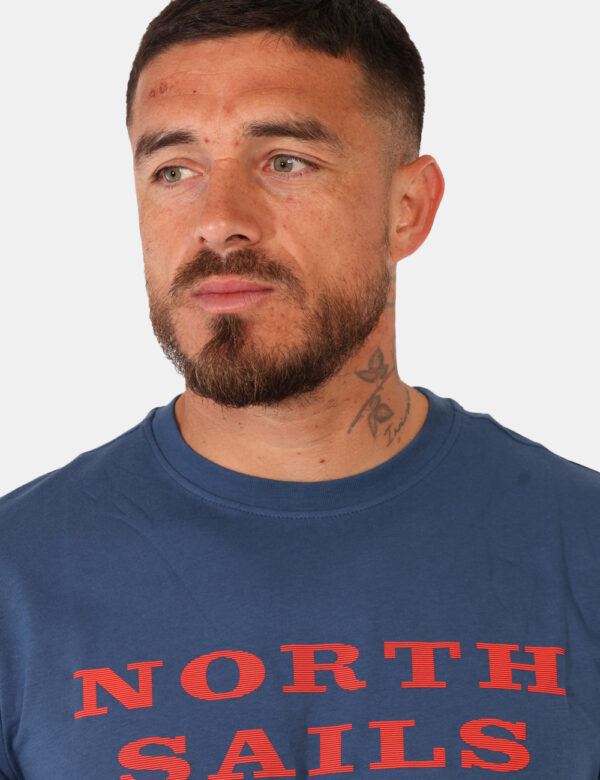 T-shirt North Sails Blu - T-shirt classica su base blu con stampa brand in arancione. La vestibilità è morbida e regolare. L