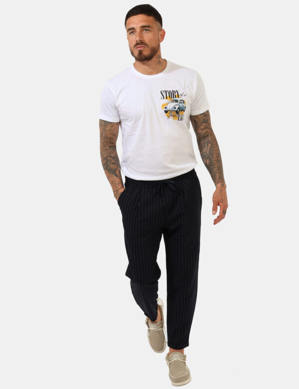 Pantaloni Goha Blu - Pantaloni gessati in total blu navy e righine bianche con tasche a taglio trasversale. La vestibilità è
