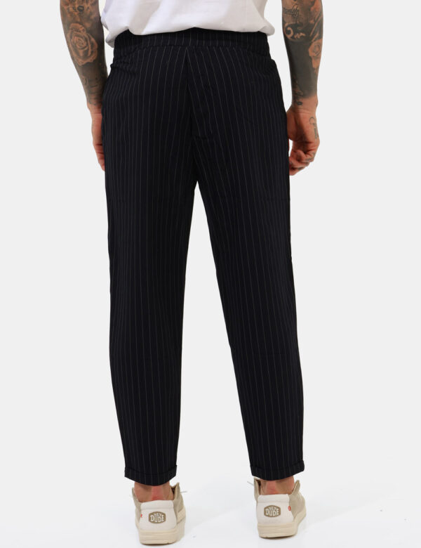 Pantaloni Goha Blu - Pantaloni gessati in total blu navy e righine bianche con tasche a taglio trasversale. La vestibilità è