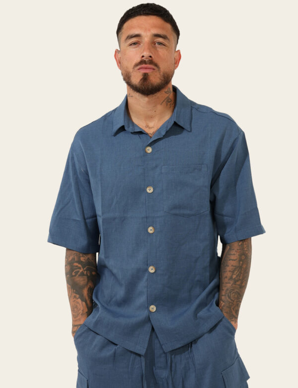 Camicia Goha Blu - Camicia in total blu denim a maniche corte, con taschino a toppa ad altezza cuore. La vestibilità è morbi
